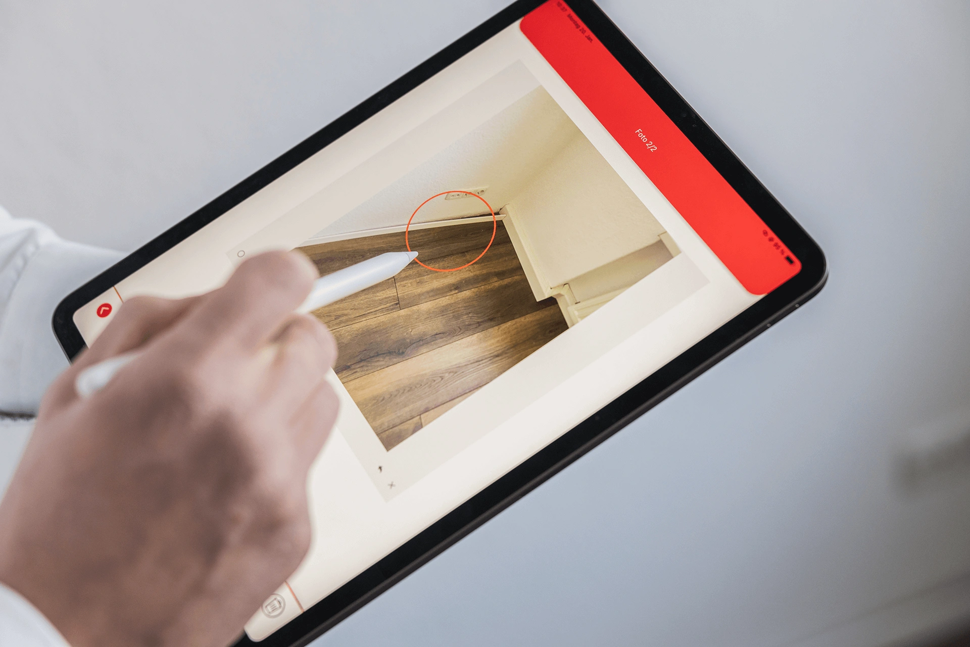 Frau fotografiert die Fassade eines Gebäudes mit einem Tablet im Rahmen einer digitalen Objektbegehung